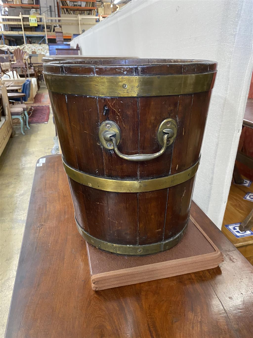 A George III circular brass bound mahogany peat bucket, fitted with two carrying handles, diameter 35.6cm, height 41cm